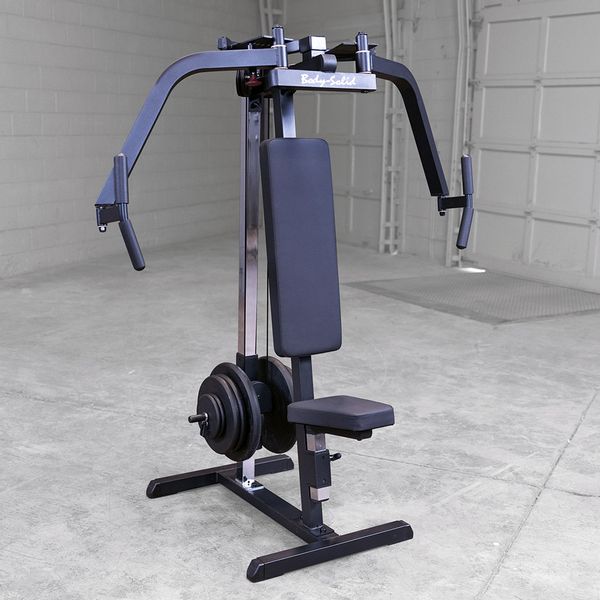 Body-Solid Pec Dec Machine GPM65B with extended articulating pec arms, demonstrating full range of motion for chest and shoulder workouts in a warehouse setting.