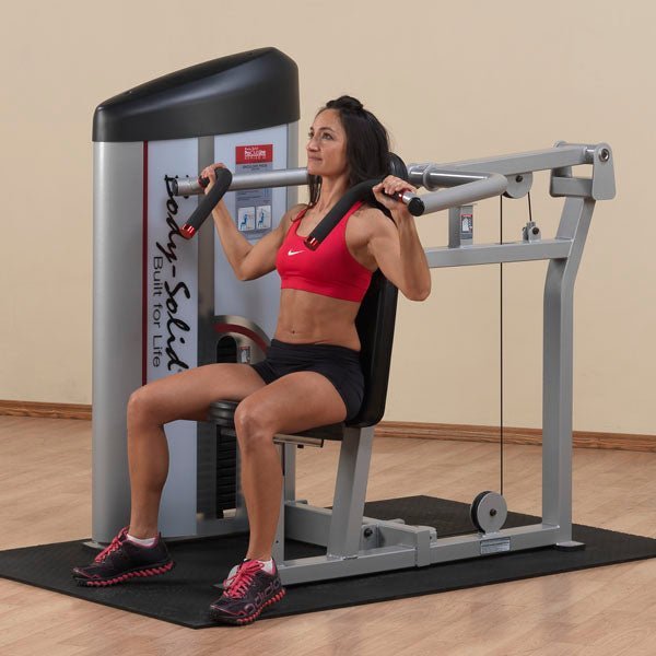 Side view of an athlete in the starting position on the Body-Solid S2SP Shoulder Press Machine, preparing for shoulder presses with multi-position hand grips.