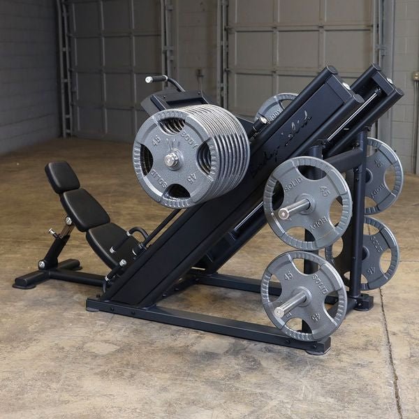 Back left side view of the Body-Solid SGLP500 Leg Press loaded with weight plates, highlighting the adjustable back pad and weight storage horns.