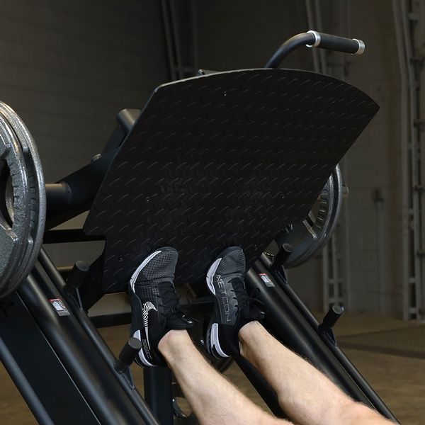 Close-up of an athlete performing calf raises on the Body-Solid SGLP500 Leg Press, focusing on foot positioning and muscle engagement.