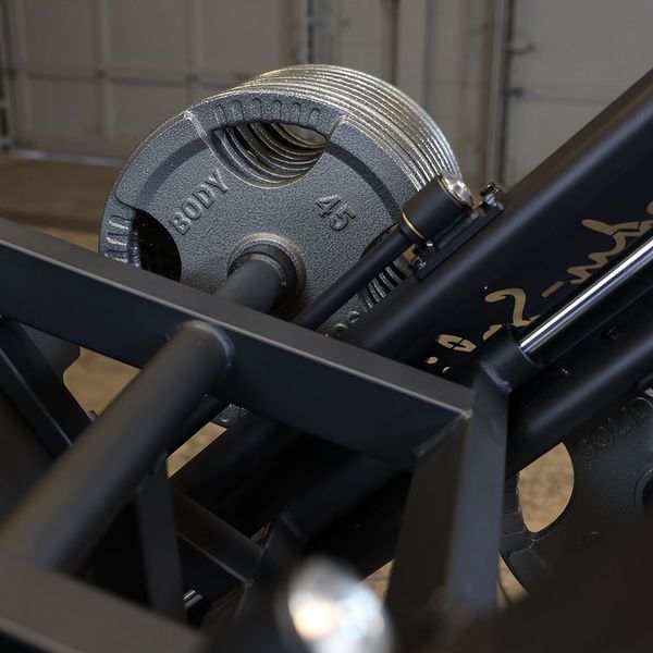 Close-up of the carriage and weight plates on the Body-Solid SGLP500 Leg Press, showing the smooth movement and plate-loaded design.