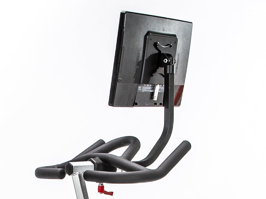 "Connect-22 tablet mounted on a BodyCraft indoor cycle, rotated to face away from the bike, demonstrating its versatility for floor exercises and as a screen for watching exercise content or entertainment."