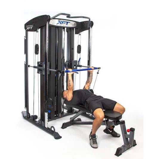 Bodycraft XFT Functional Trainer side with all white background and bench and athlete bench pressing