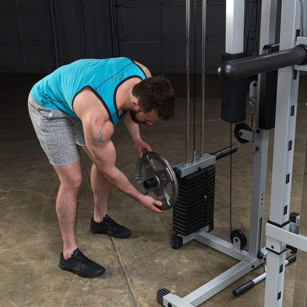 Powerline Smith Machine Package showing close up of male athlete loading 2" cast iron weight plates to the weight stack 2" plate horn