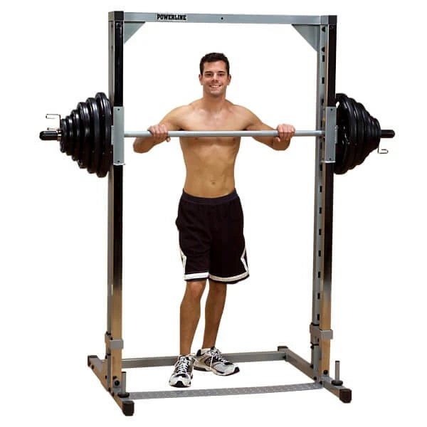 Body-Solid Powerline Smith Machine PSM144X for home gym strength training male athlete posing at bar loaded up with cast iron weight plates