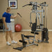 White male in a blue shirt performing a one-arm bicep curl using a cable attachment on the Powerline by Body-Solid P2X Multi-Functional Home Gym.