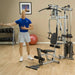 White male in a blue shirt performing a lateral cable pull from the mid pulley on the Powerline by Body-Solid P2X Multi-Functional Home Gym.