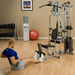 Person performing a seated row exercise on the Powerline P2X Home Gym with a close-up of cable handle and weight stack for effective back workout.