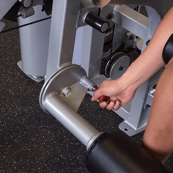 Close-up view of a user adjusting the leg extension pad on the Pro Clubline Leg Extension Leg Curl Combo Series II S2LEC, demonstrating the machine's adjustable settings for personalized comfort and optimal exercise positioning.