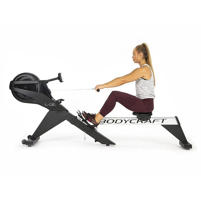 Female athlete rowing on the BodyCraft VR500 Pro Rower Machine, demonstrating the smooth and ergonomic design, with adjustable footrests and a high-tech console, perfect for home or commercial use.